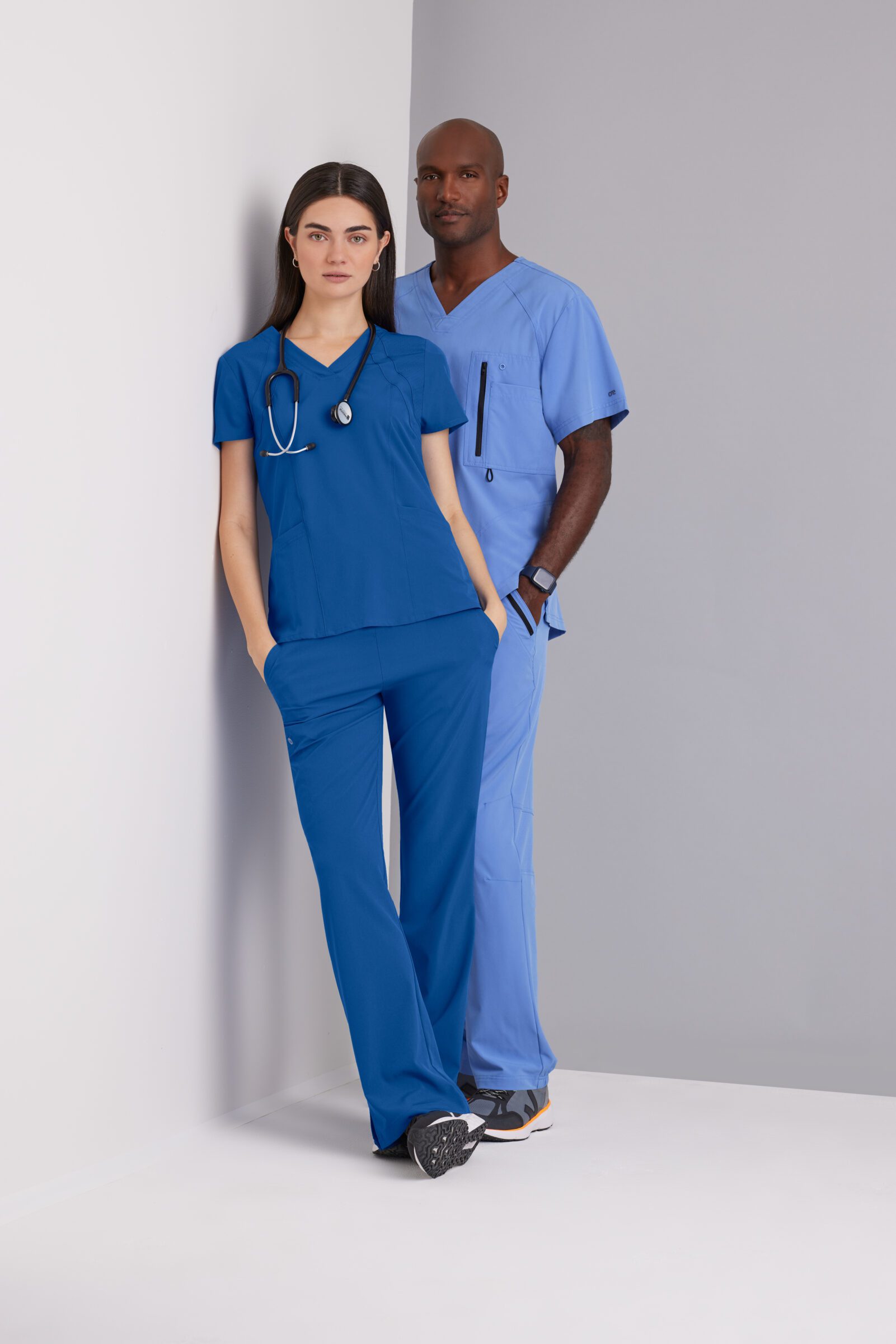 Two healthcare professionals wearing blue Barco One medical scrubs